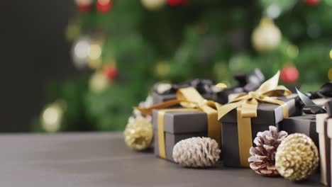 Video-of-christmas-gifts-with-pine-cones-and-copy-space-on-black-background