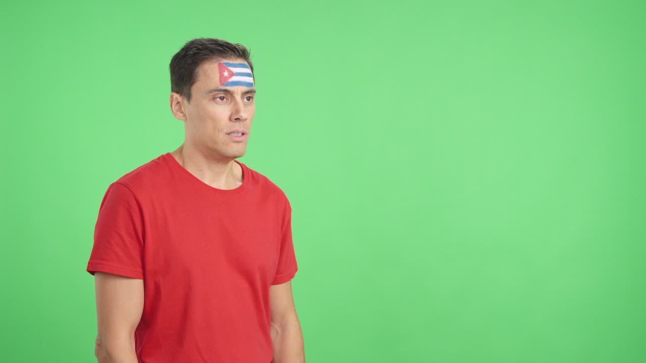 Happy man with cuban flag painted on face looking away