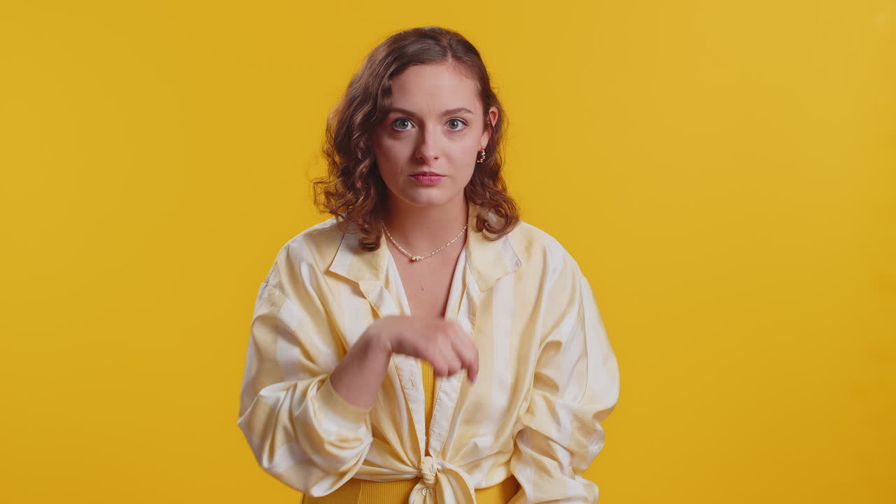 Young woman presses finger to lips makes silence gesture sign do not tells secret stop gossip