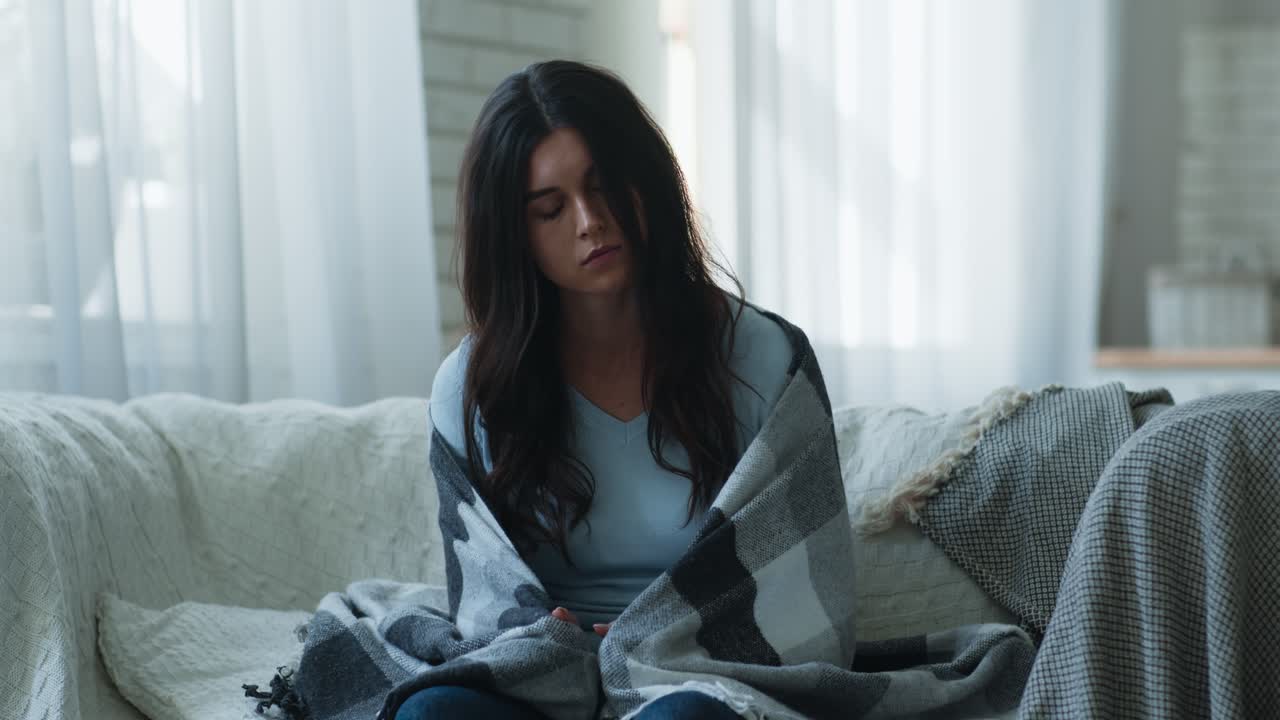 소파에 담요로 싸인 여자