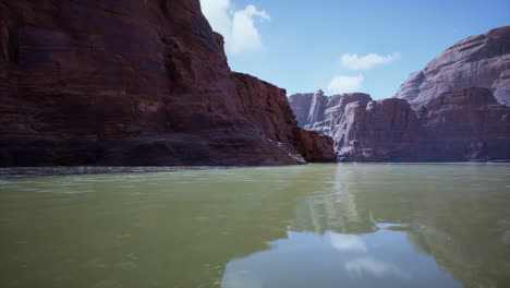 a serene view of a canyon with a river in the foreground