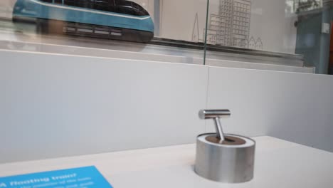 Hand interacts with lever toy at museum display