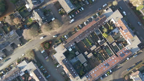 Top-down-aerial-of-a-beautiful-suburban-area-with-a-single-car-driving-over-road