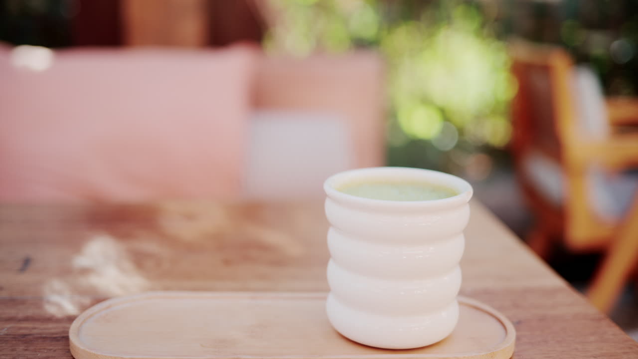 Wooden restaurant table prepared with glasses, plates, and napkins in warm natural light