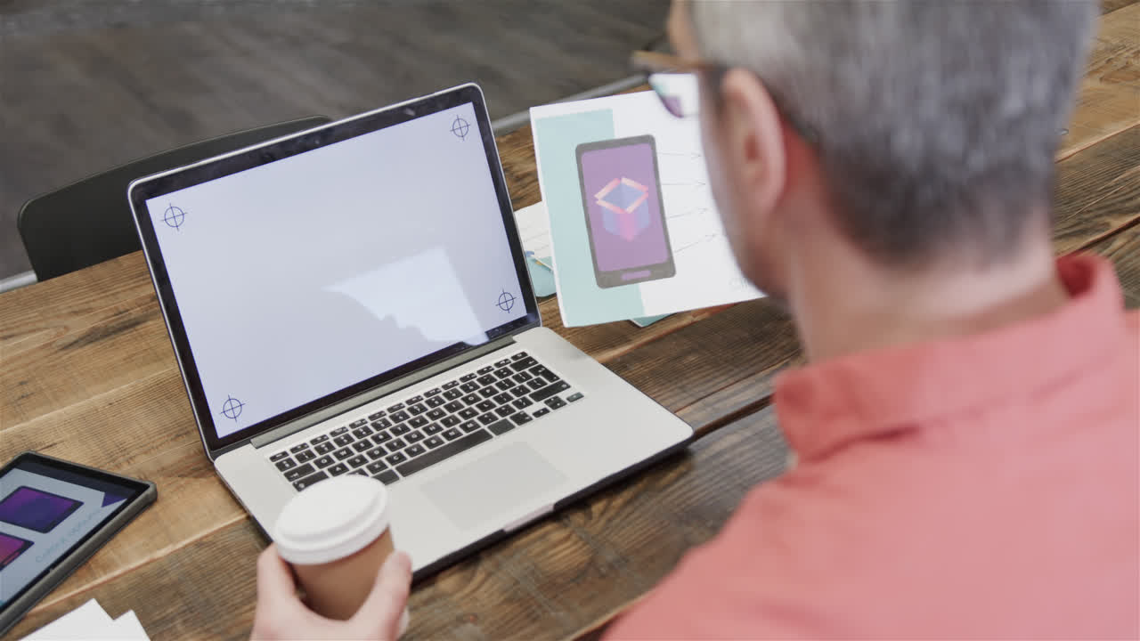 diseñador masculino caucásico senior haciendo una llamada de video en la computadora portátil con espacio de copia en la pantalla, cámara lenta