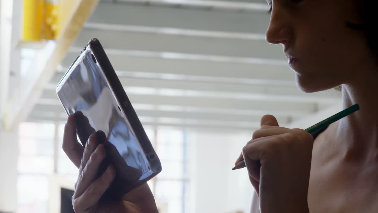 Carpenter using digital tablet in workshop 4k