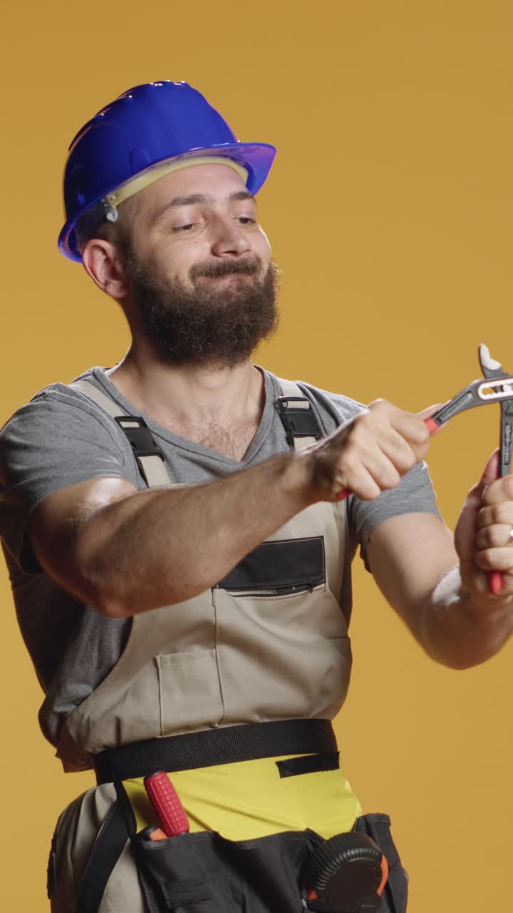 Vertical video: Construction craftsman working with steel wrench on renovation