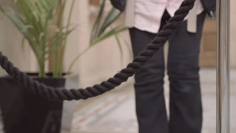 person walking toward event rope stanchion in lobby of building