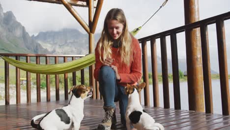 caucasian couple spending time at home together, playing with dogs