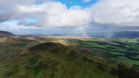 Enfoque-De-Drones-De-Colina-Cónica-En-Escocia-Con-Arco-Iris-Detrás