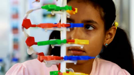 un escolar experimentando con un modelo de molécula en el laboratorio 4k