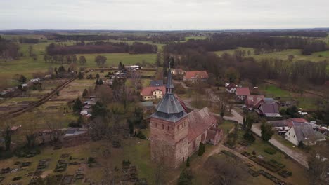 Atemberaubende-Luftaufnahme-Flug-Dorfkirche-Lüssow-Mecklenburg-Vorpommern-Deutschland-Winter-2023