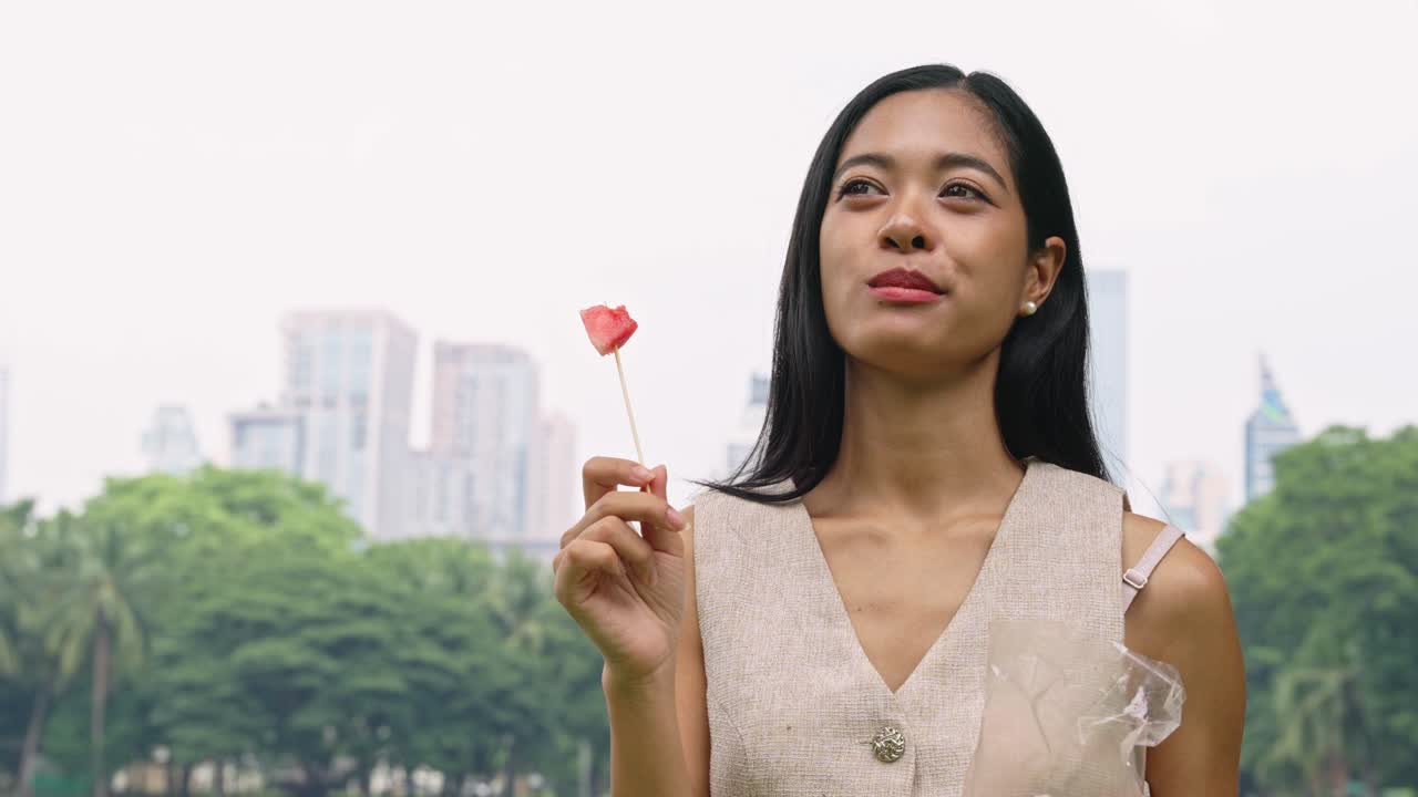 Woman eating watermelon in the park