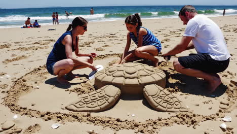 family building a sand turtle on the beach