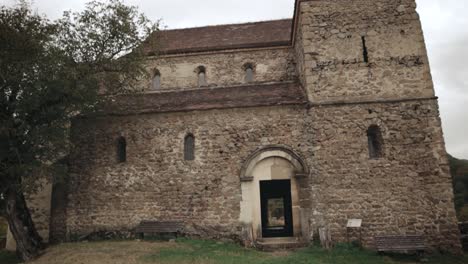 Tilting-down-up-shot-of-an-old-medieval-Saxon-fortified-stone-built-church