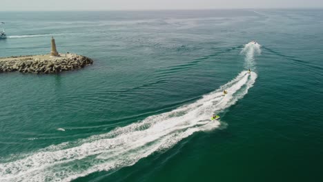 Jet-Ski-Rennen-In-Der-Nähe-Eines-Leuchtturms-In-Puerto-Banus,-Marbella,-Luftaufnahme