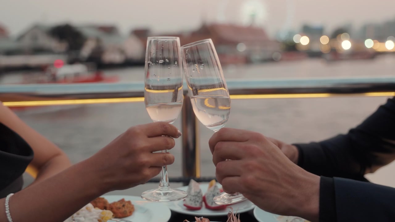 Coppia che brinda con calici di champagne durante una cena romantica