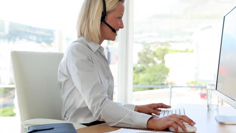 Mujer-De-Negocios-Rubia-Que-Trabaja-Con-Un-Auricular