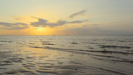 Barcos-En-El-Horizonte-Vista-De-Bajo-Nivel-Con-Mar-En-Calma-En-Cámara-Lenta-Durante-La-Puesta-De-Sol-En-Fleetwood,-Lancashire,-Reino-Unido