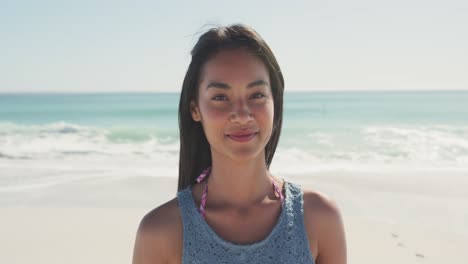 mixed race woman  laughing at beach and looking at the camera