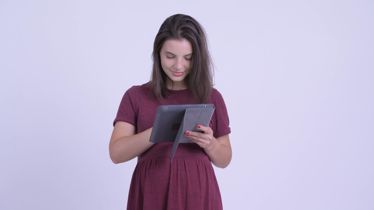 feliz joven hermosa mujer embarazada con tableta digital