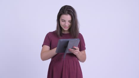 feliz joven hermosa mujer embarazada con tableta digital