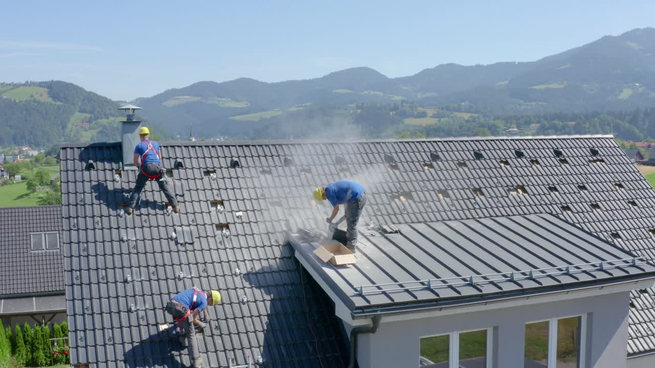 Aerial circling over workers installing solar panels on house rooftop. Slovenia