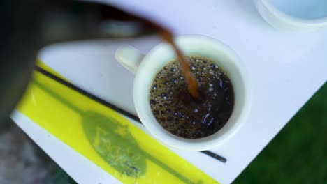 verter café etíope en una taza, addis abeba, etiopía