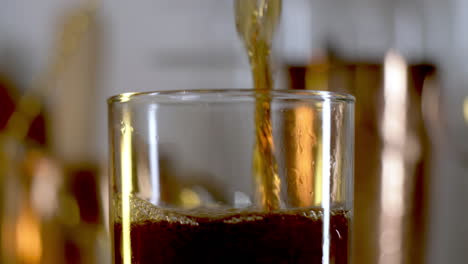 soda poured in to rocks glass in slow motion, close up