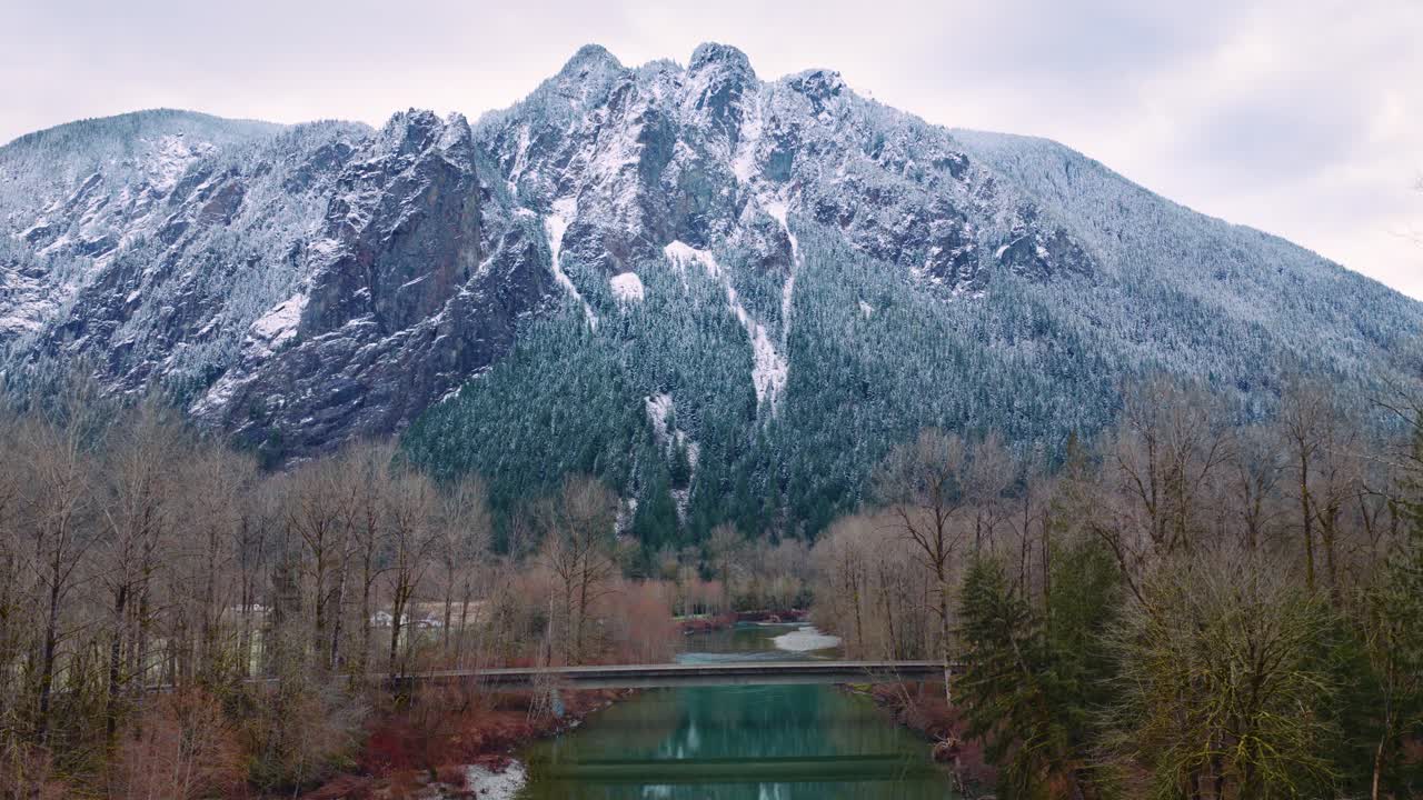 Riprese con drone che mostrano il Monte Si a North Bend, Washington, coperto di neve, con alberi sempreverdi circostanti e il fiume Snoqualmie. Perfetto per progetti sulla natura, viaggi o attività all'aperto.