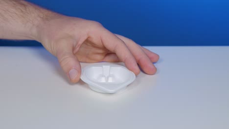 colocar un vaso de orina de plástico blanco para la recogida de muestras para pruebas en el hogar