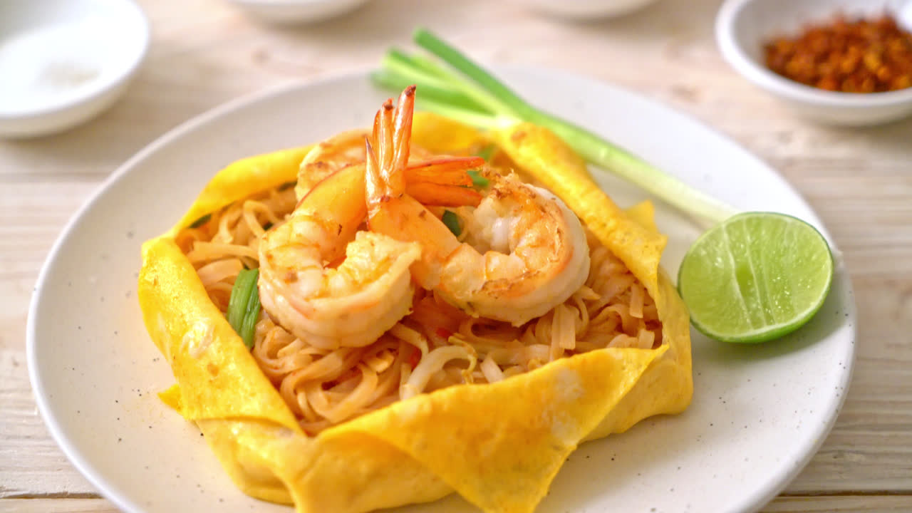 Thai stir fried noodles with shrimps and egg wrap (Pad Thai) - Thai food style