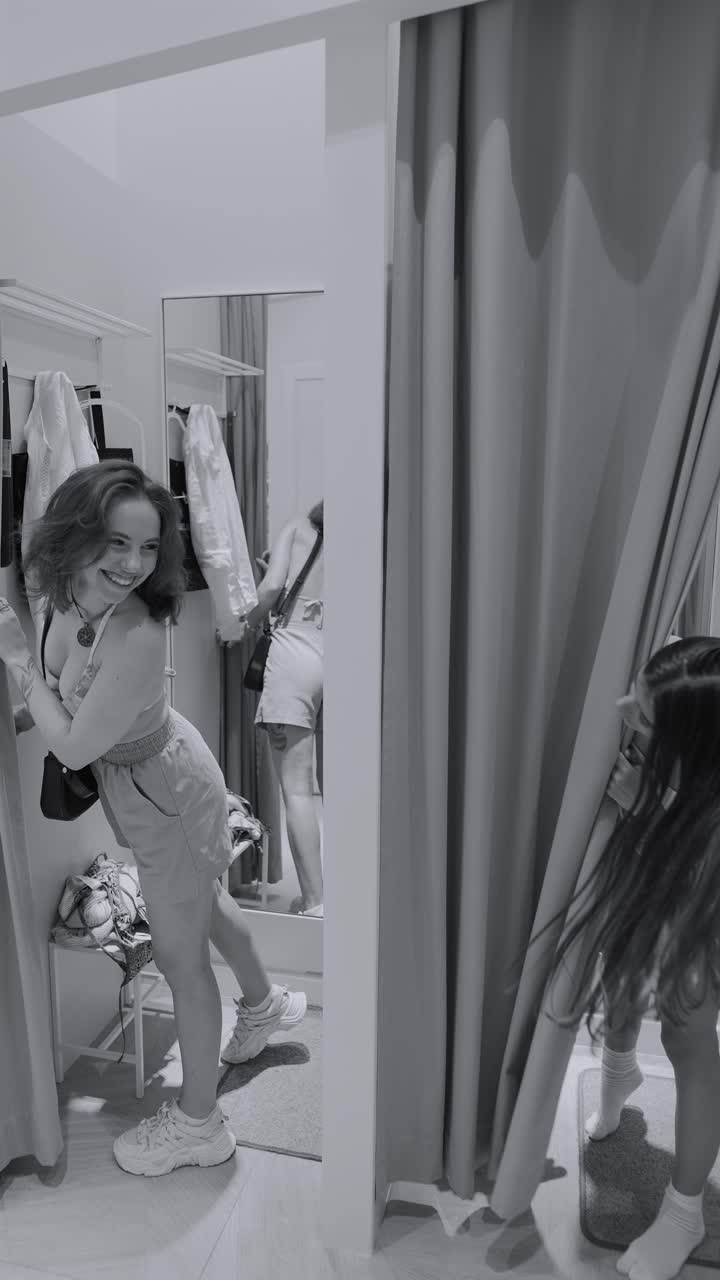 여자 들 이 착용실 에서 옷 을 시도 하고 있다