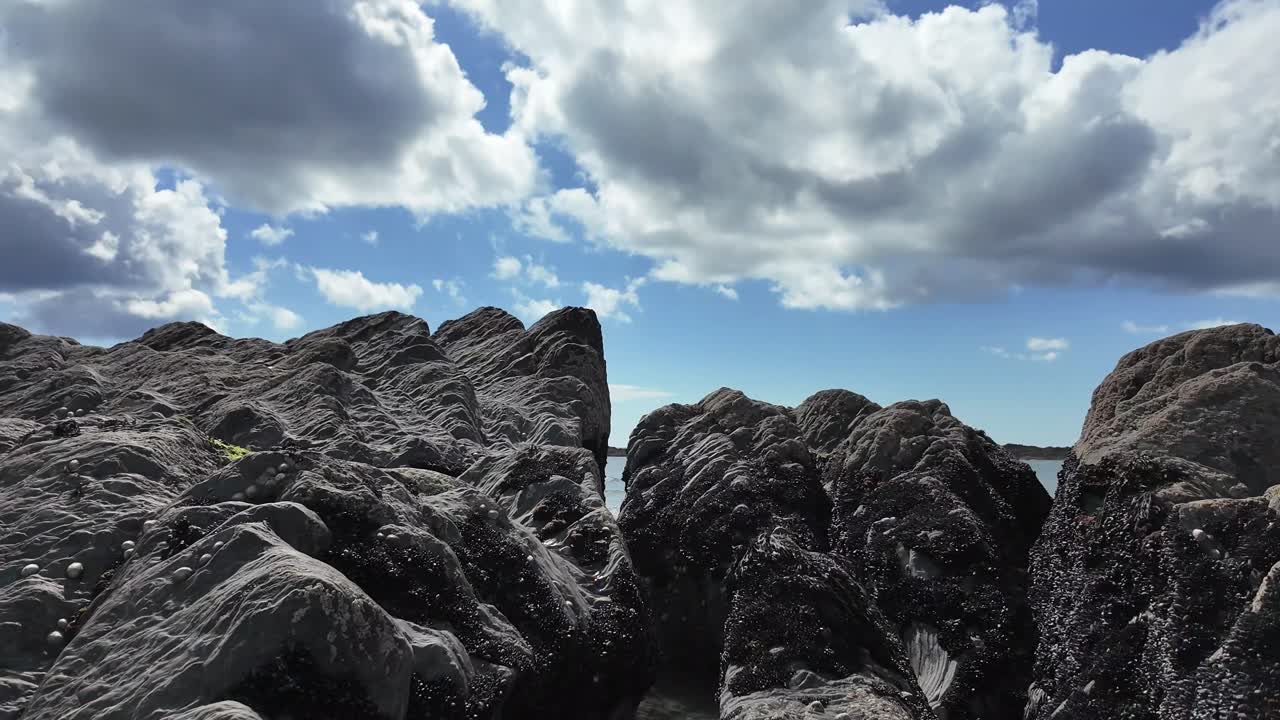 cielo dramático con nubes blancas hinchadas en azul, con capas de formación rocosa con músculos pegados en él