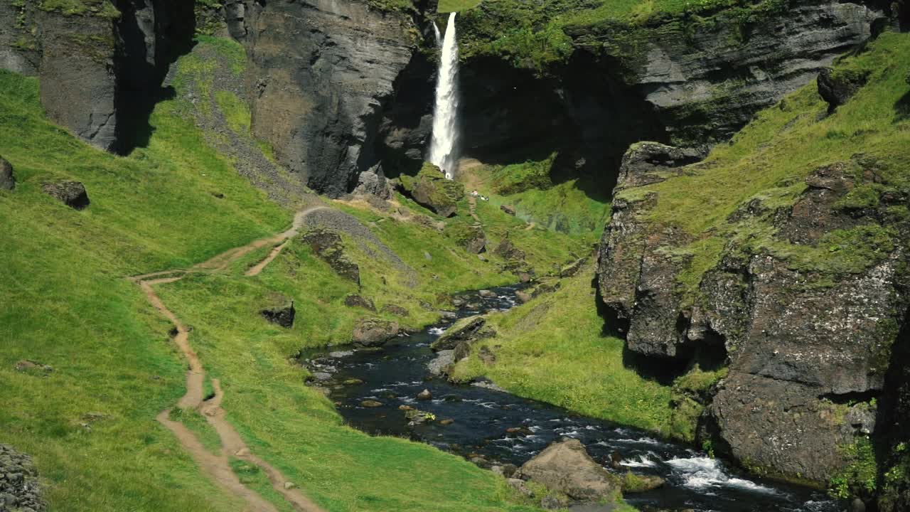 hombre tocando la guitarra frente a una hermosa cascada en islandia-19