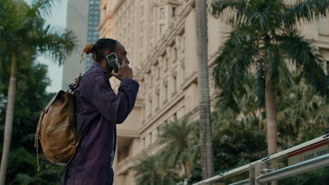 man walking in city, using smartphone