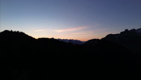 Aerial-View-of-Sunrise-in-the-Austrian-Alps-with-Birds-flying-close-by,-Snow-covered-Summits-in-Background-in-Bludenz,-Austria,-Europe