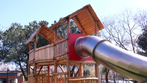 patio de recreo de madera con tobogán de metal