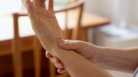 close up of old woman hands massaging on her wrist