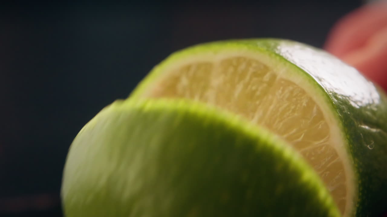 Primo piano di un barista che affetta lime fresco per la preparazione di cocktail al bar