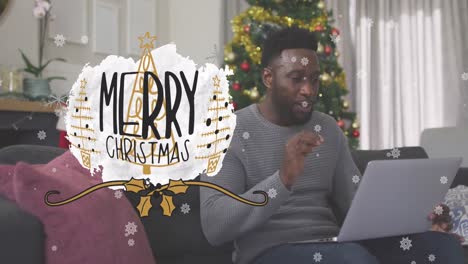 Animation-of-merry-christmas-over-african-american-man-having-video-call-on-laptop