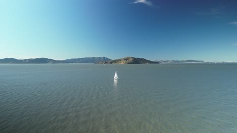 Aerial drone shot of Treasure Island with a boat in the day and the North Pacific Ocean in California, USA