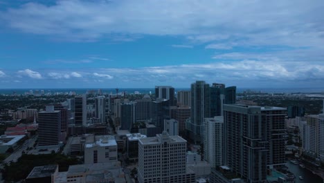 aerial drone shot of cityscapes with tall buildings and dark blue cloudy sky