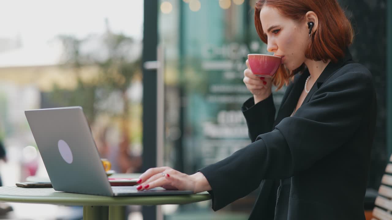 Donna che lavora al portatile in un caffè