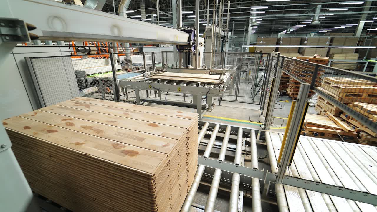 Process of manufacturing of wooden boards. Automatic line leaves finished products. Wood industry. Plant of parquet
