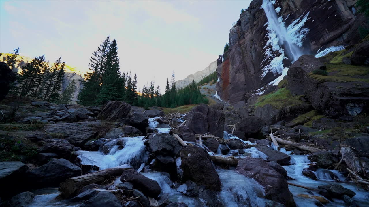Bridal Veil Falls Telluride Colorado sunset stream frozen ice Waterfall fall autumn orange peaceful sunset cool shaded Rocky Mountains Silverton Ouray historic town scenic landscape slow pan wide