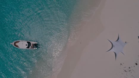 Drone-Top-view-Tropical-luxury-paradise-beach-tent-and-speedboat-moored-clear-water,-Los-Roques