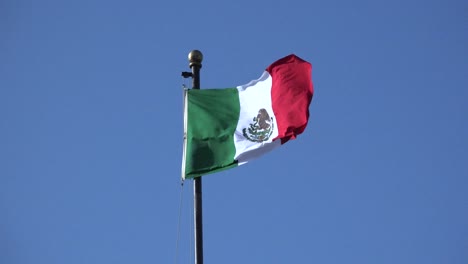 Vista-De-Cerca-De-La-Bandera-Mexicana-Que-Sopla-En-El-Viento-En-El-Poste