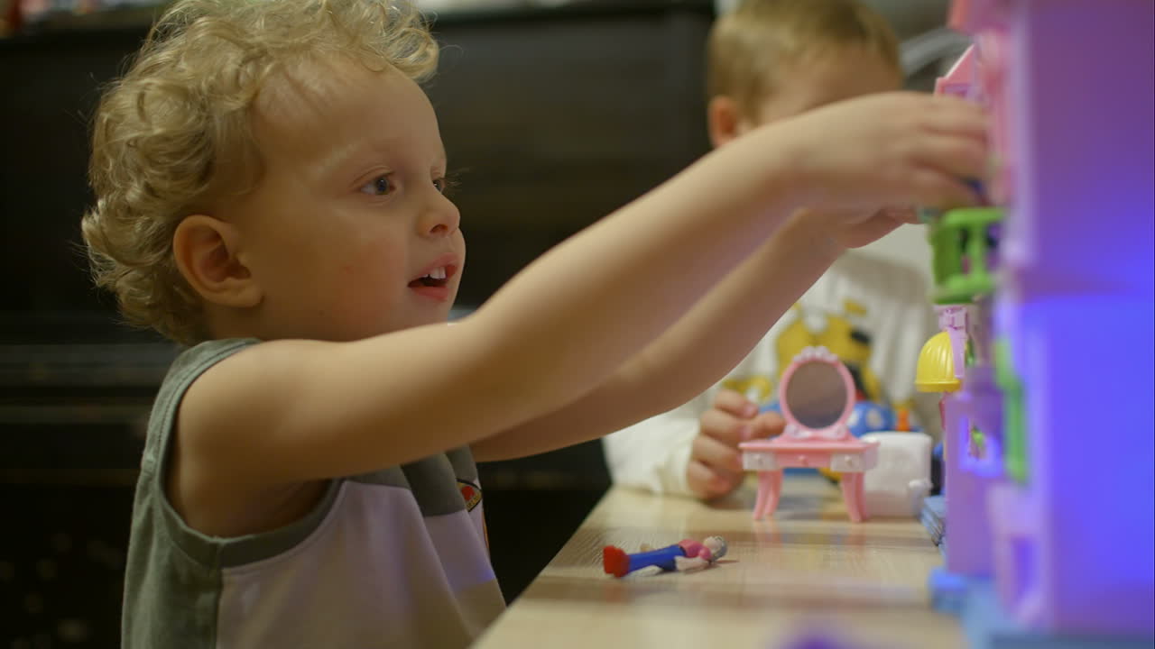 Little boys playing with toy house at home