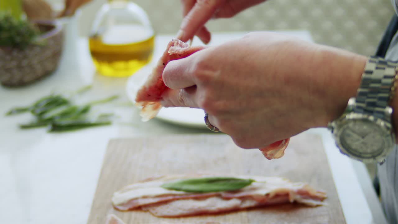 Woman putting raw saltimbocca on wooden stick